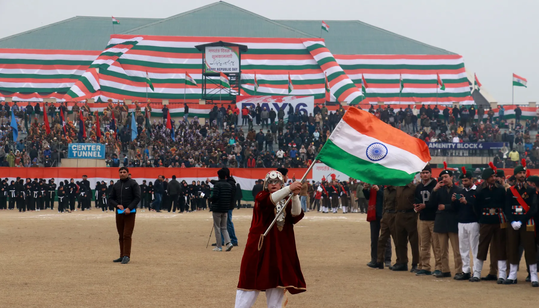 A woman waves the national flag during the Republic Day function at Bakshi stadium in Srinagar on Friday. Mubashir Khan for Greater Kashmir